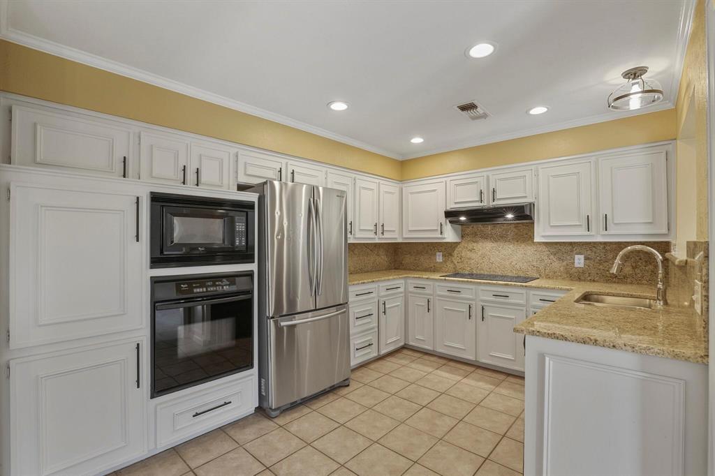 15632 Moondust Drive Dallas, TX 75248 - Photo 19 of 36 a kitchen with granite countertop cabinets stainless steel appliances and a sink