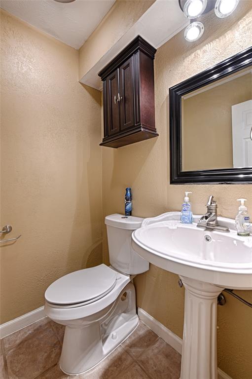 15632 Moondust Drive Dallas, TX 75248 - Photo 24 of 36 a bathroom with a toilet a sink and mirror