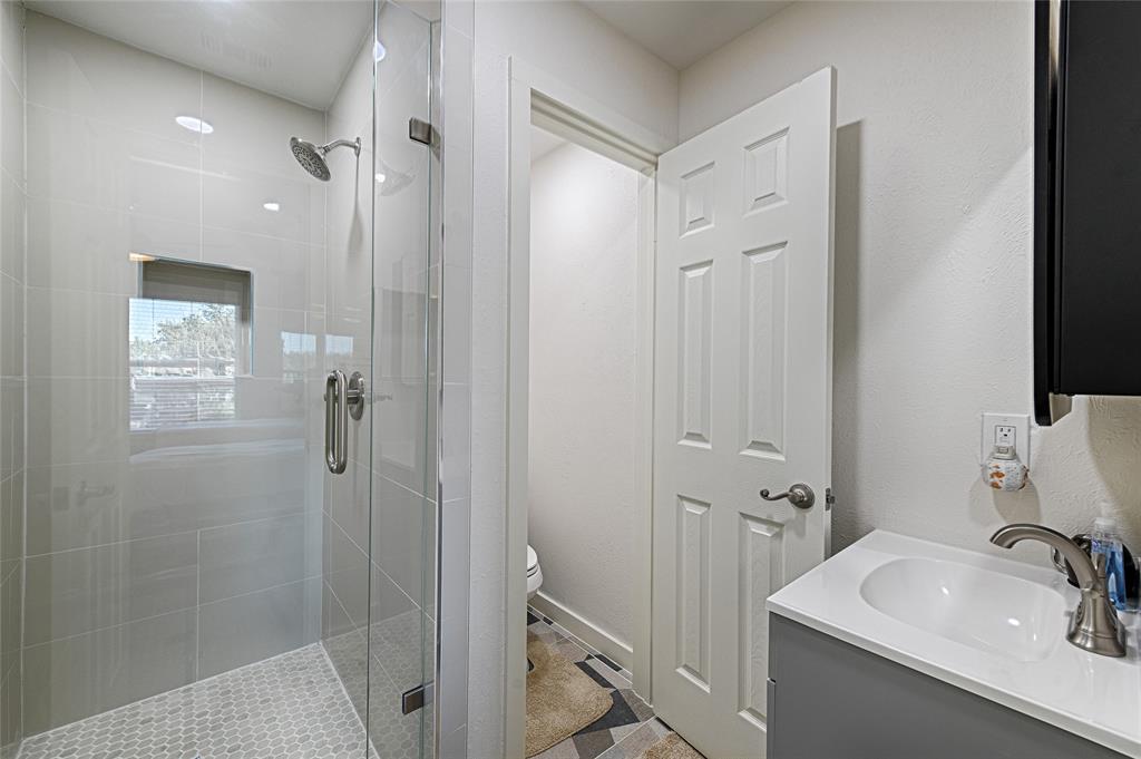 15632 Moondust Drive Dallas, TX 75248 - Photo 28 of 36 a bathroom with a sink a toilet and shower