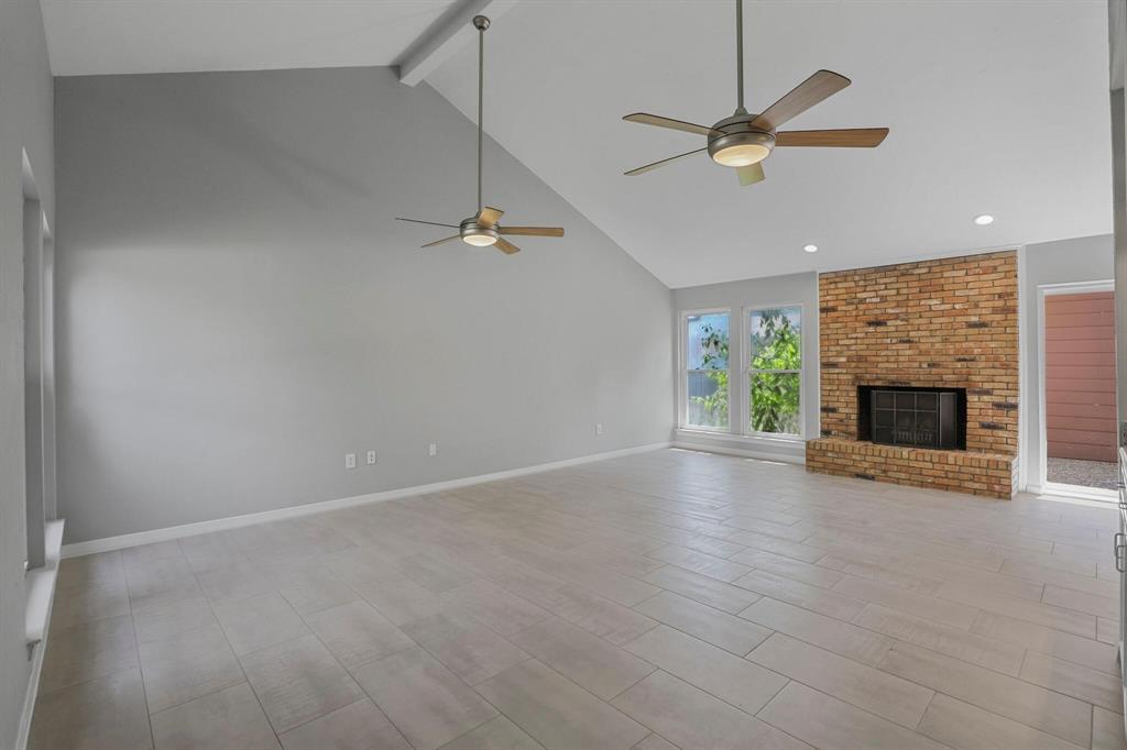 15632 Moondust Drive Dallas, TX 75248 - Photo 5 of 36 an empty room with ceiling fan and a fireplace