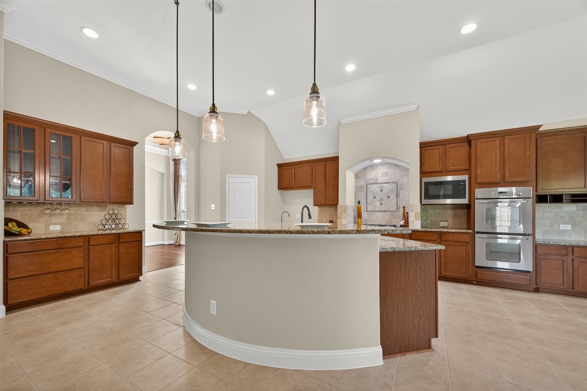 21331 Winding Path Way Richmond, TX 77406 - Photo 12 of 42 a kitchen with stainless steel appliances granite countertop a sink a stove a refrigerator and island with wooden floor