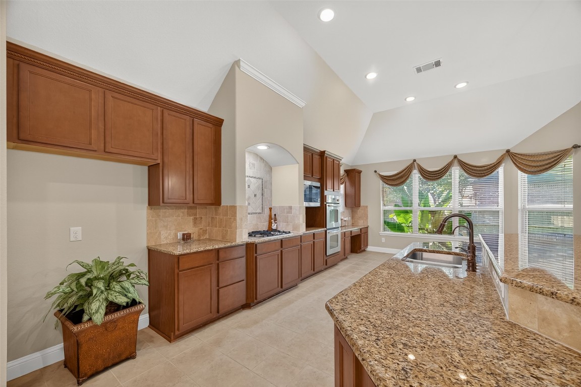 21331 Winding Path Way Richmond, TX 77406 - Photo 14 of 42 a large kitchen with stainless steel appliances kitchen island granite countertop a large refrigerator a sink dishwasher and cabinets