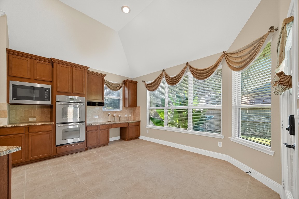 21331 Winding Path Way Richmond, TX 77406 - Photo 17 of 42 a kitchen with stainless steel appliances a large window and a refrigerator