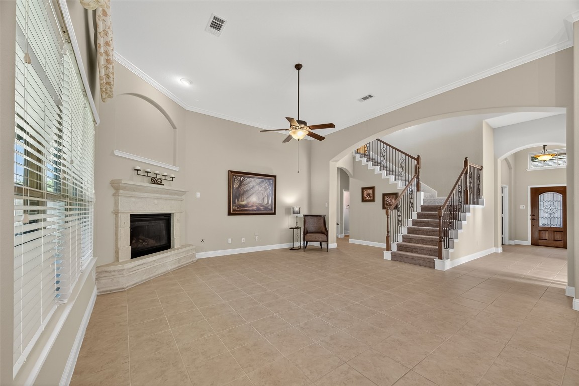 21331 Winding Path Way Richmond, TX 77406 - Photo 10 of 42 an empty room with fireplace stairs and windows