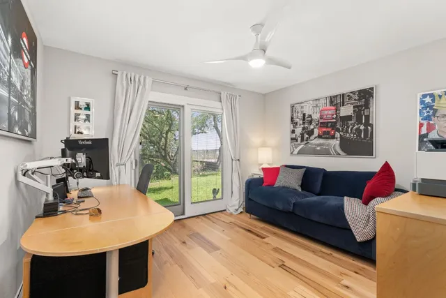 a bedroom with a bed a table and three large mirror with a window