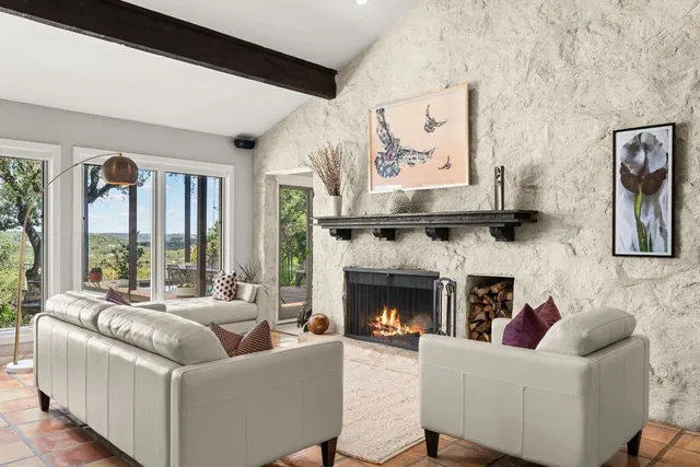 a living room with furniture large window and a fireplace