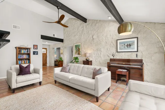 a living room with furniture and a piano