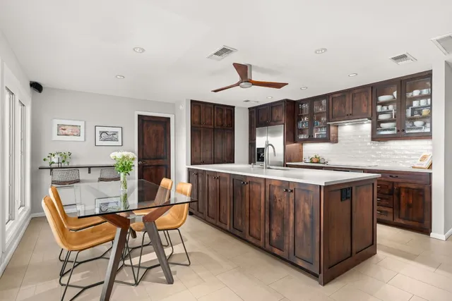 a dining hall with stainless steel appliances granite countertop a stove and a sink