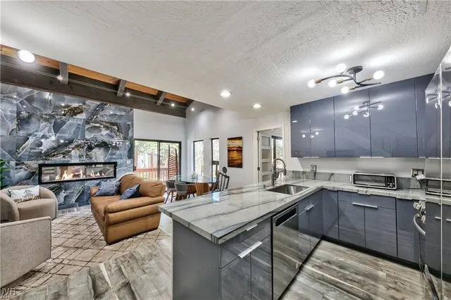 a kitchen with stainless steel appliances granite countertop a sink and a refrigerator