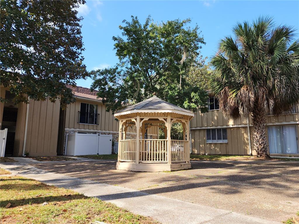507 Northwest 39th Road, Unit 237 Gainesville, FL 32607 - Photo 20 of 21 a view of a house with a swimming pool and a large tree