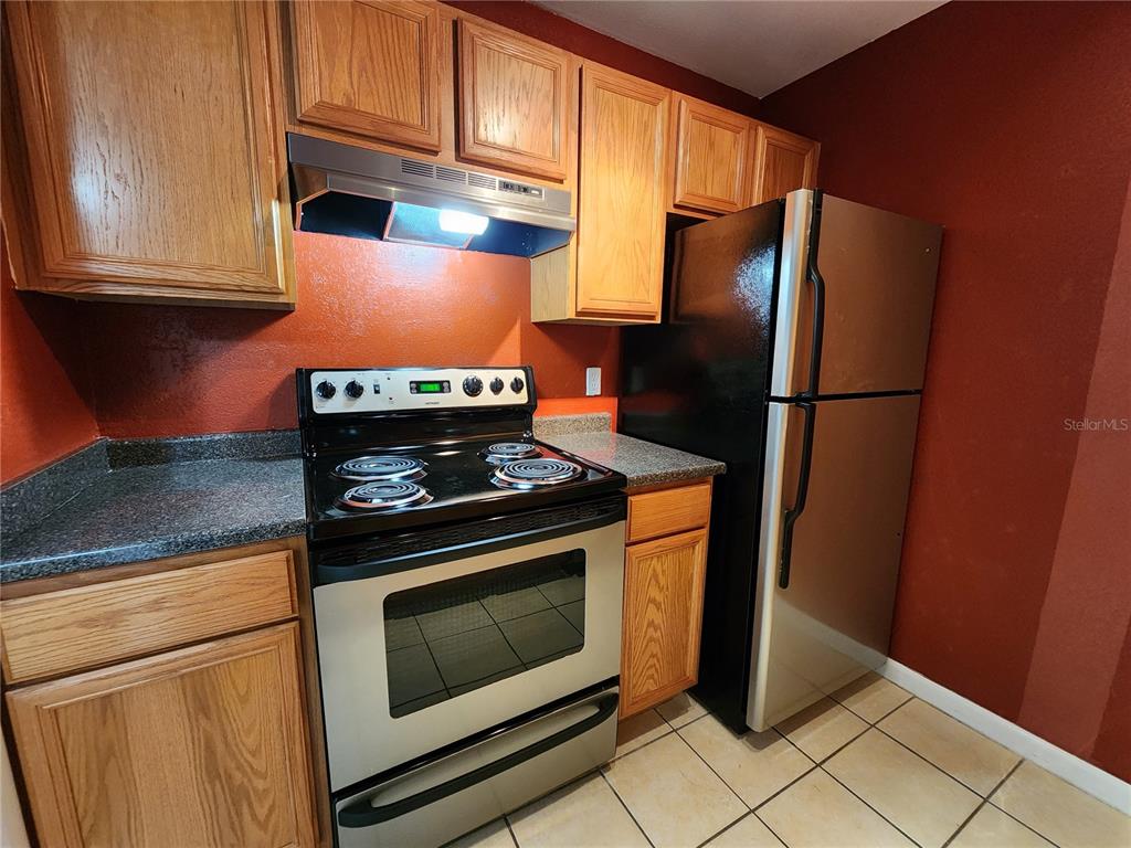 507 Northwest 39th Road, Unit 237 Gainesville, FL 32607 - Photo 6 of 21 a kitchen with stainless steel appliances granite countertop a refrigerator stove and microwave