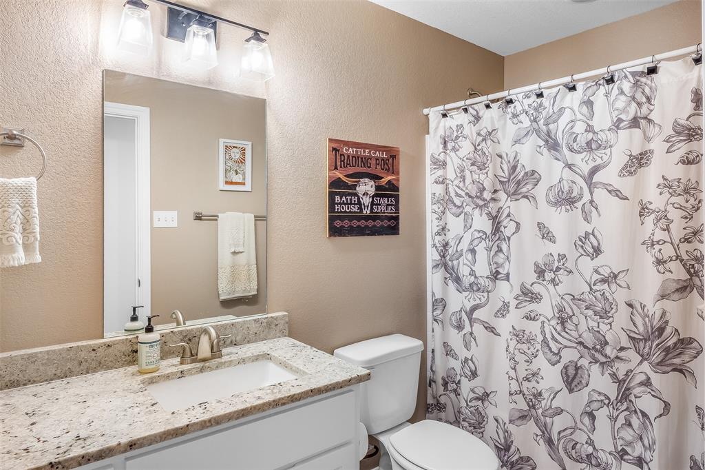 161 Columbia Street Cleburne, TX 76031 - Photo 14 of 19 a bathroom with a granite countertop sink and a mirror
