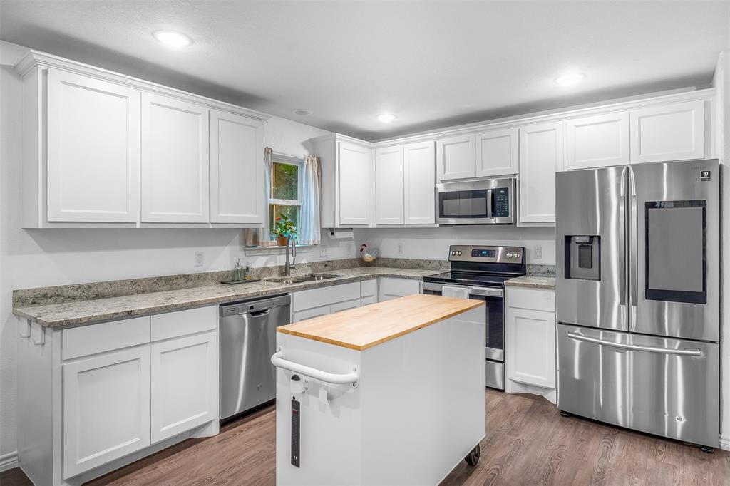 161 Columbia Street Cleburne, TX 76031 - Photo 5 of 19 a kitchen with a sink white cabinets and stainless steel appliances