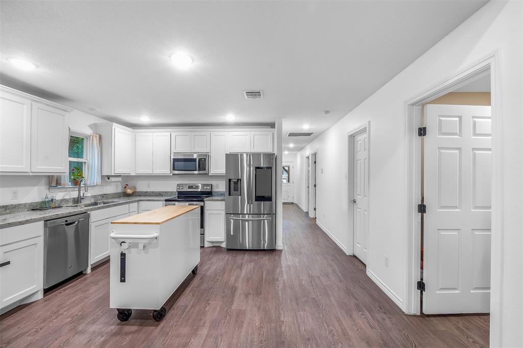 161 Columbia Street Cleburne, TX 76031 - Photo 6 of 19 a large kitchen with a lot of counter space and wooden floor