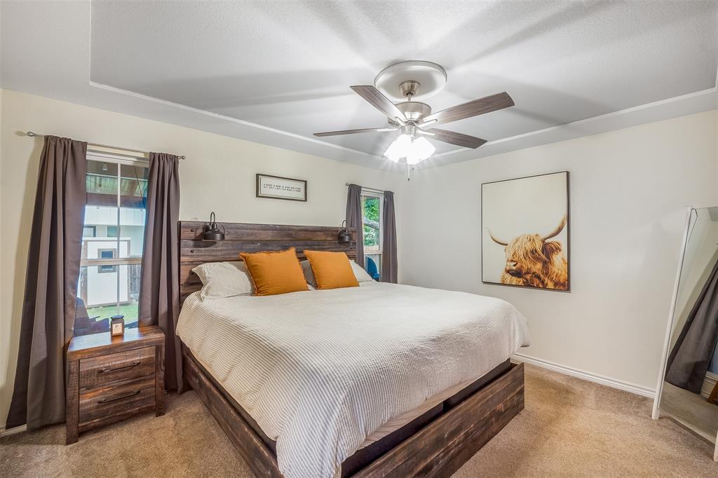 161 Columbia Street Cleburne, TX 76031 - Photo 9 of 19 a bedroom with a large bed and a chandelier