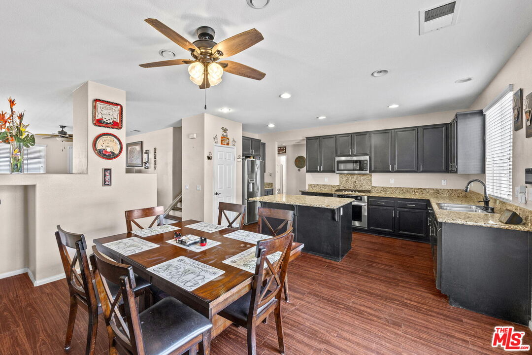 26692 Rim Creek Path Menifee, CA 92584 - Photo 7 of 41 a kitchen with a table chairs a sink dishwasher stove and cabinets with wooden floor