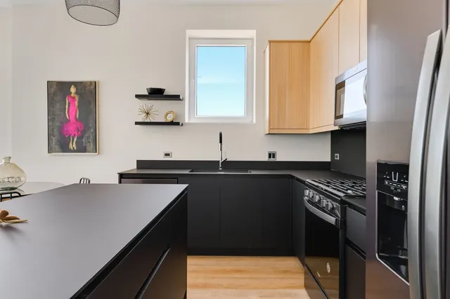 a kitchen with stainless steel appliances granite countertop a sink stove and refrigerator