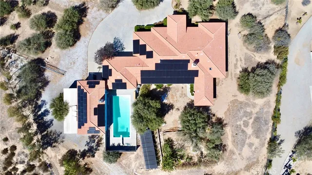 an aerial view of a house with a yard and large trees