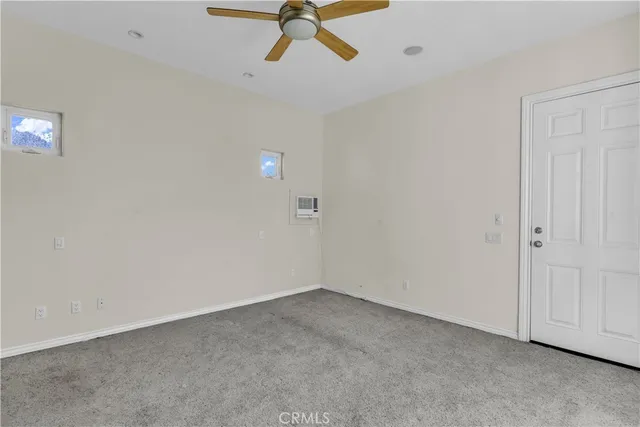 a view of a room with a ceiling fan and window