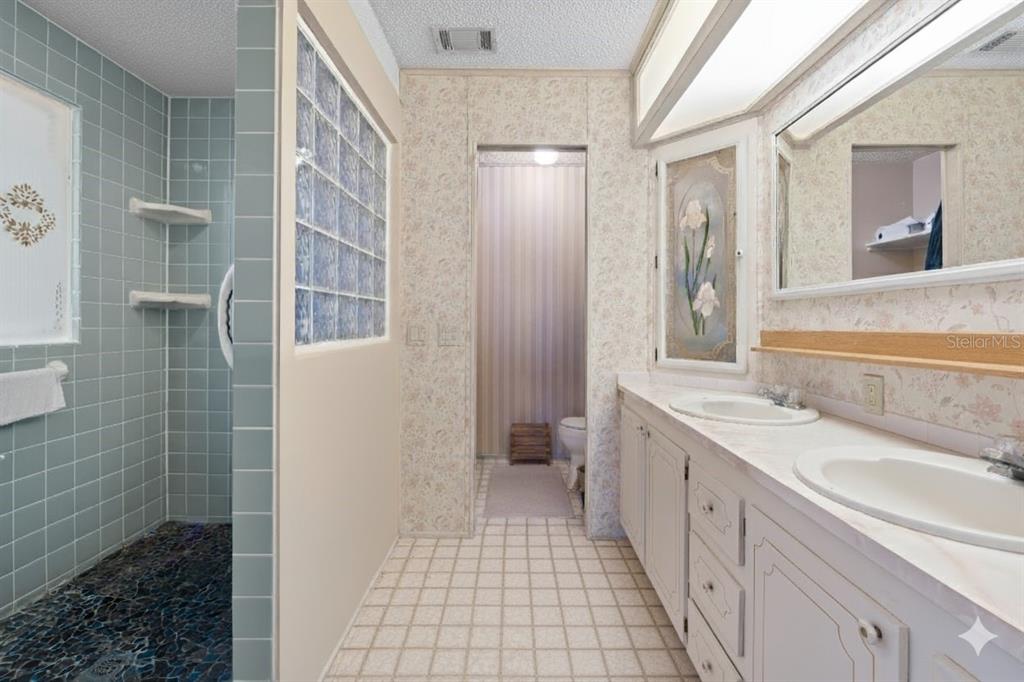 2673 Cayman Circle, Unit R38 Zellwood, FL 32798 - Photo 16 of 63 a bathroom with a granite countertop sink a toilet a mirror and shower