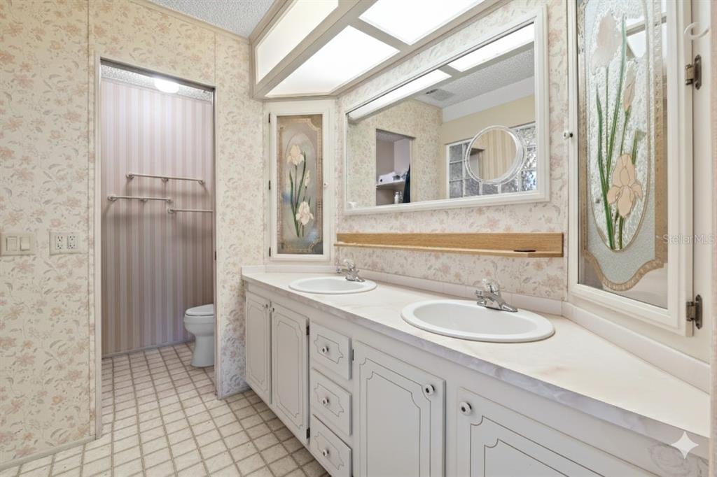 2673 Cayman Circle, Unit R38 Zellwood, FL 32798 - Photo 17 of 63 a spacious bathroom with a double vanity sink a mirror and a shower