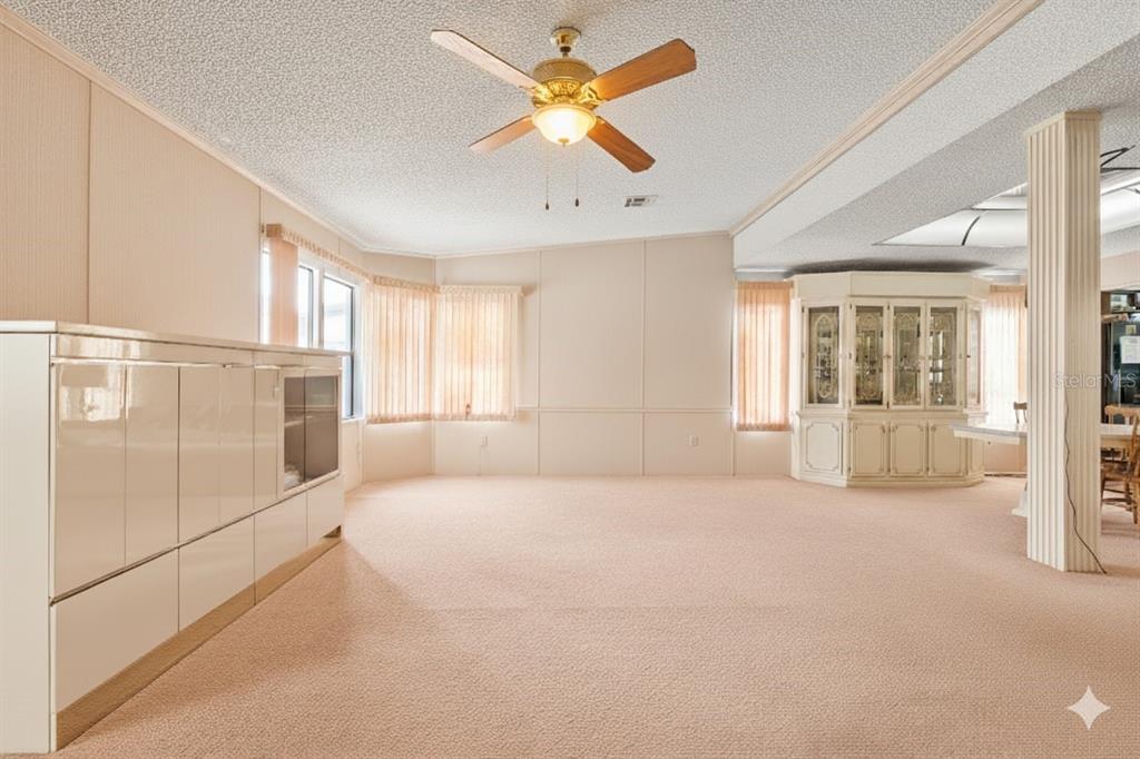 2673 Cayman Circle, Unit R38 Zellwood, FL 32798 - Photo 7 of 63 a big room with windows and ceiling fan