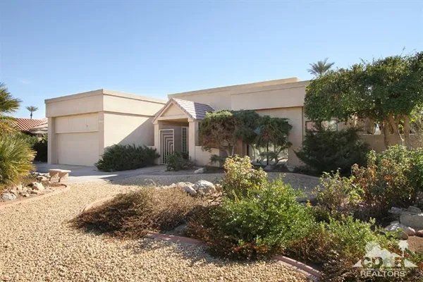 a view of a house with a yard and pathway