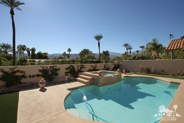 a view of a swimming pool with a yard and sitting area