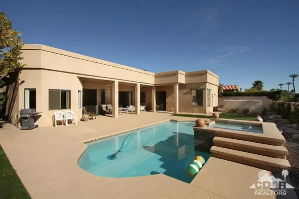 a view of a house with pool and chairs