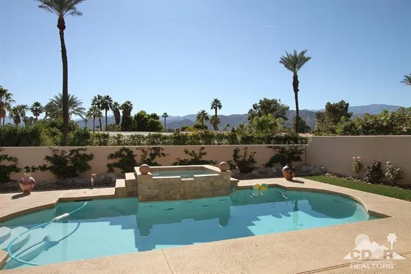 a view of a swimming pool with a yard and mountain view