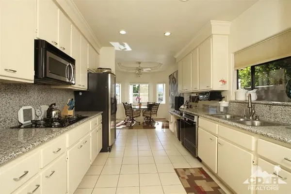 a kitchen with stainless steel appliances a sink a stove top oven a sink a counter space and cabinets