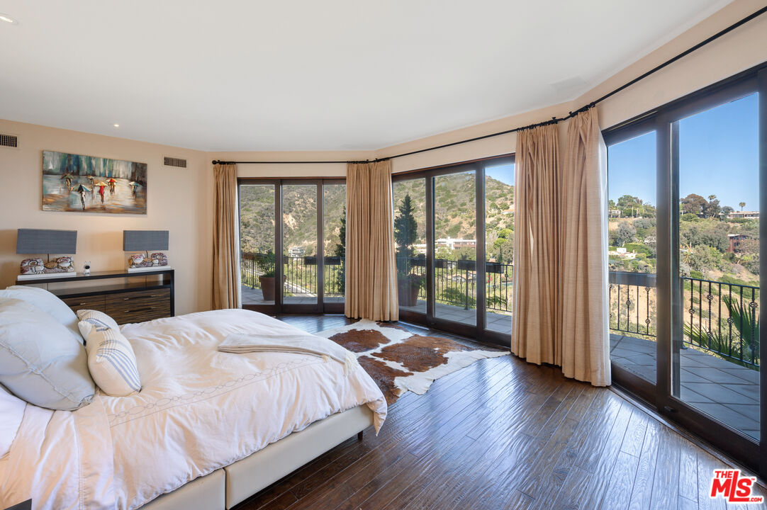 3854 Rambla Orienta Malibu, CA 90265 - Photo 13 of 33 a bedroom with a bed and a large window