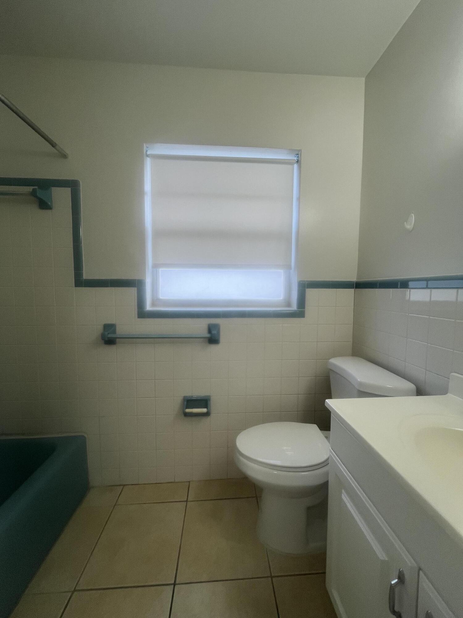 1017 Southeast 3rd Street, Unit 5 Deerfield Beach, FL 33441 - Photo 14 of 16 a bathroom with a toilet a sink and mirror