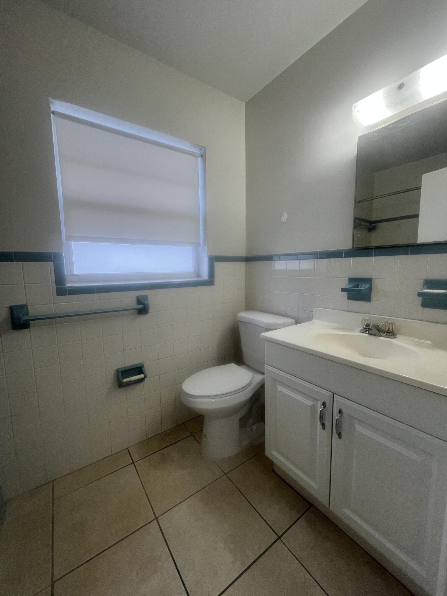 1017 Southeast 3rd Street, Unit 5 Deerfield Beach, FL 33441 - Photo 15 of 16 a bathroom with a toilet sink and mirror