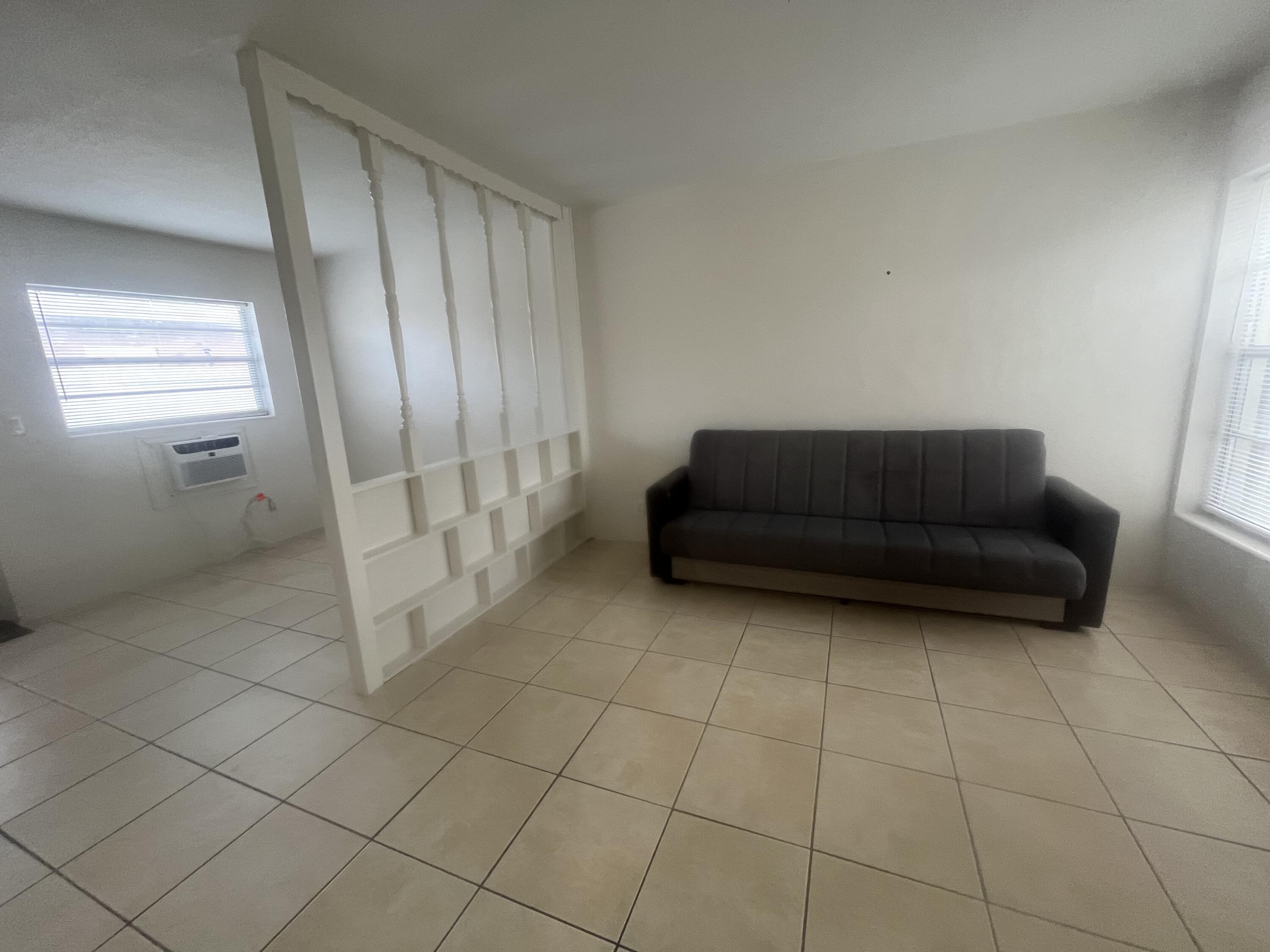 1017 Southeast 3rd Street, Unit 5 Deerfield Beach, FL 33441 - Photo 9 of 16 a living room with a couch and a shower