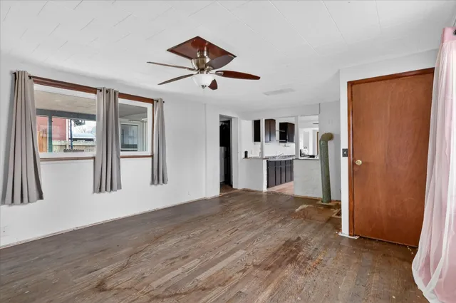 a view of a big room with wooden floor and windows