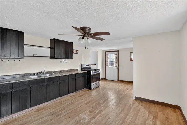 a kitchen with stainless steel appliances granite countertop a sink cabinets and wooden floor