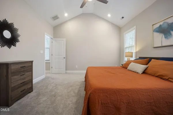a spacious bedroom with a bed and a potted plant