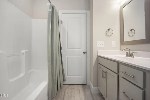 a bathroom with a granite countertop sink toilet a large mirror and a window