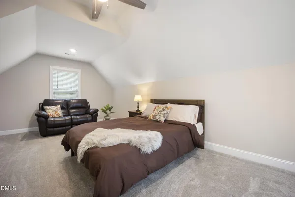 a bed sitting in a bedroom next to a window
