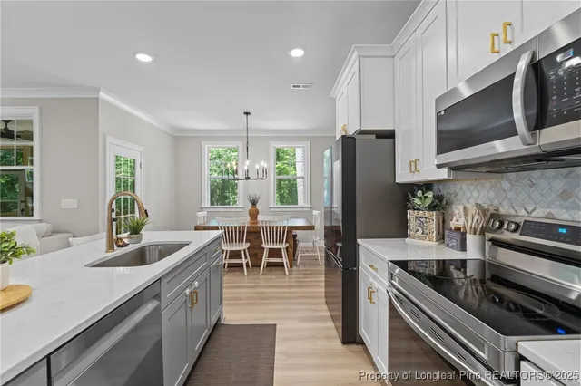 a kitchen with counter top space a sink appliances and cabinets