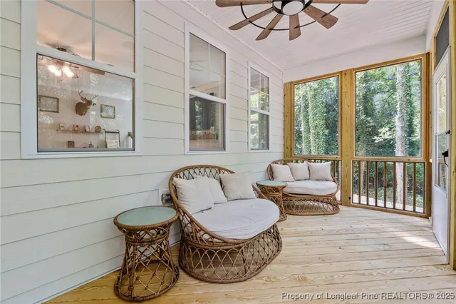 a living room with furniture a flat screen tv and a floor to ceiling window