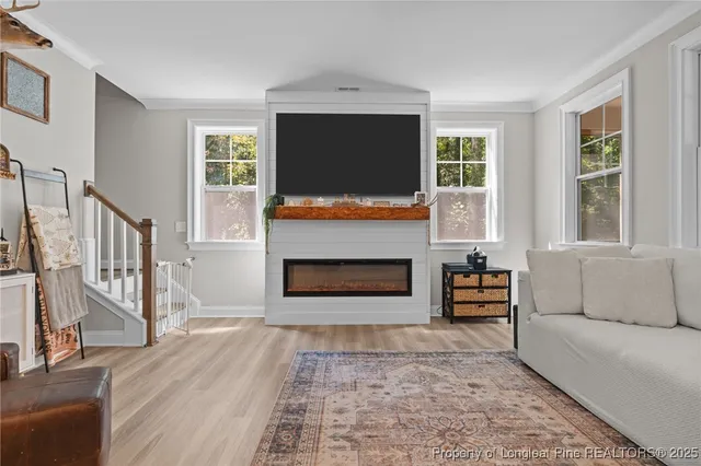 a living room with furniture a flat screen tv and a fireplace