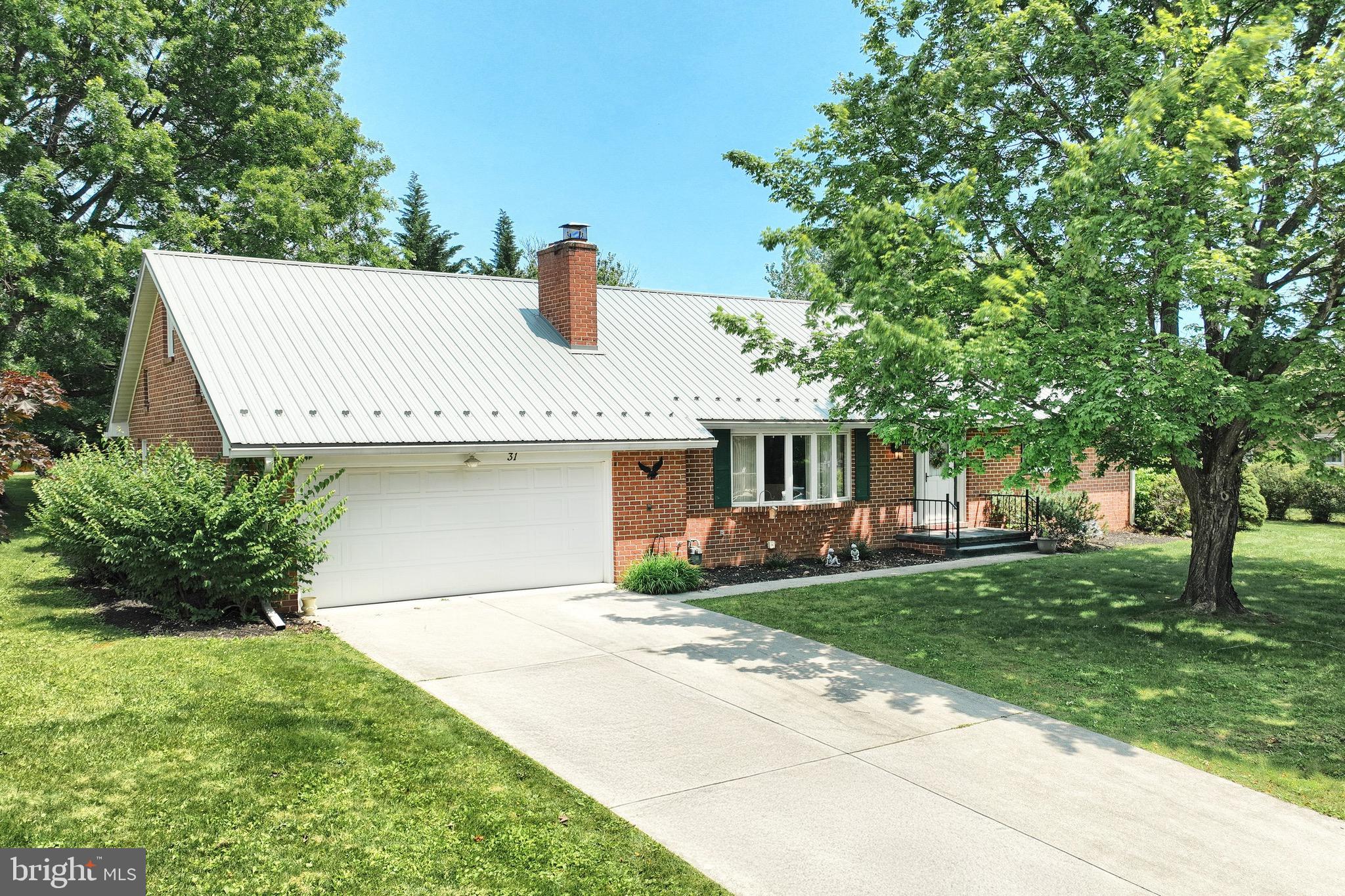 a front view of a house with a garden and tree