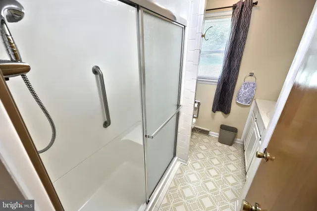 a bedroom with a bed and a dresser next to a window