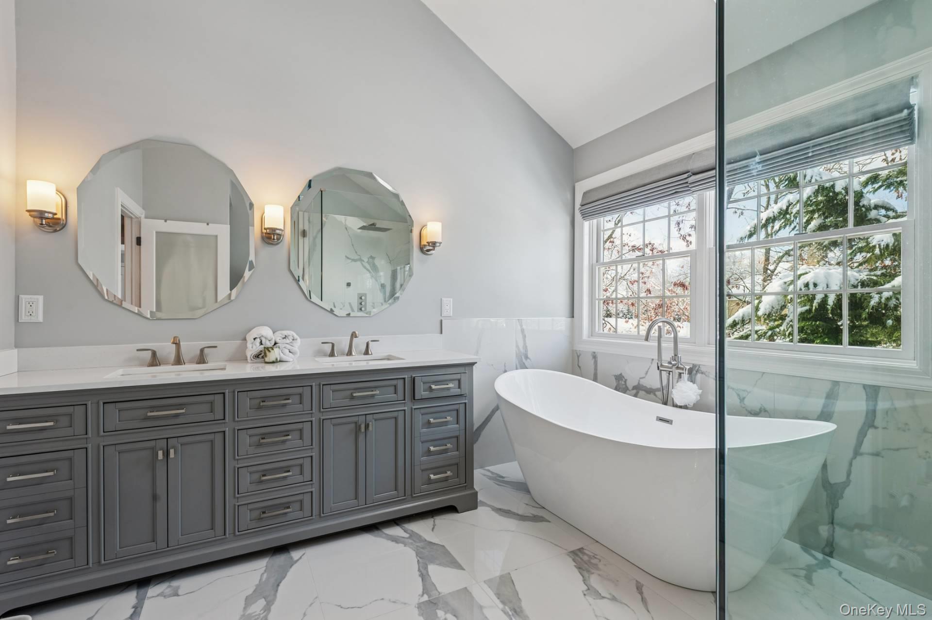 47 Bathing Beach Road Southampton, NY 11968 - Photo 13 of 20 a spacious bathroom with a double vanity sink a mirror and a bathtub
