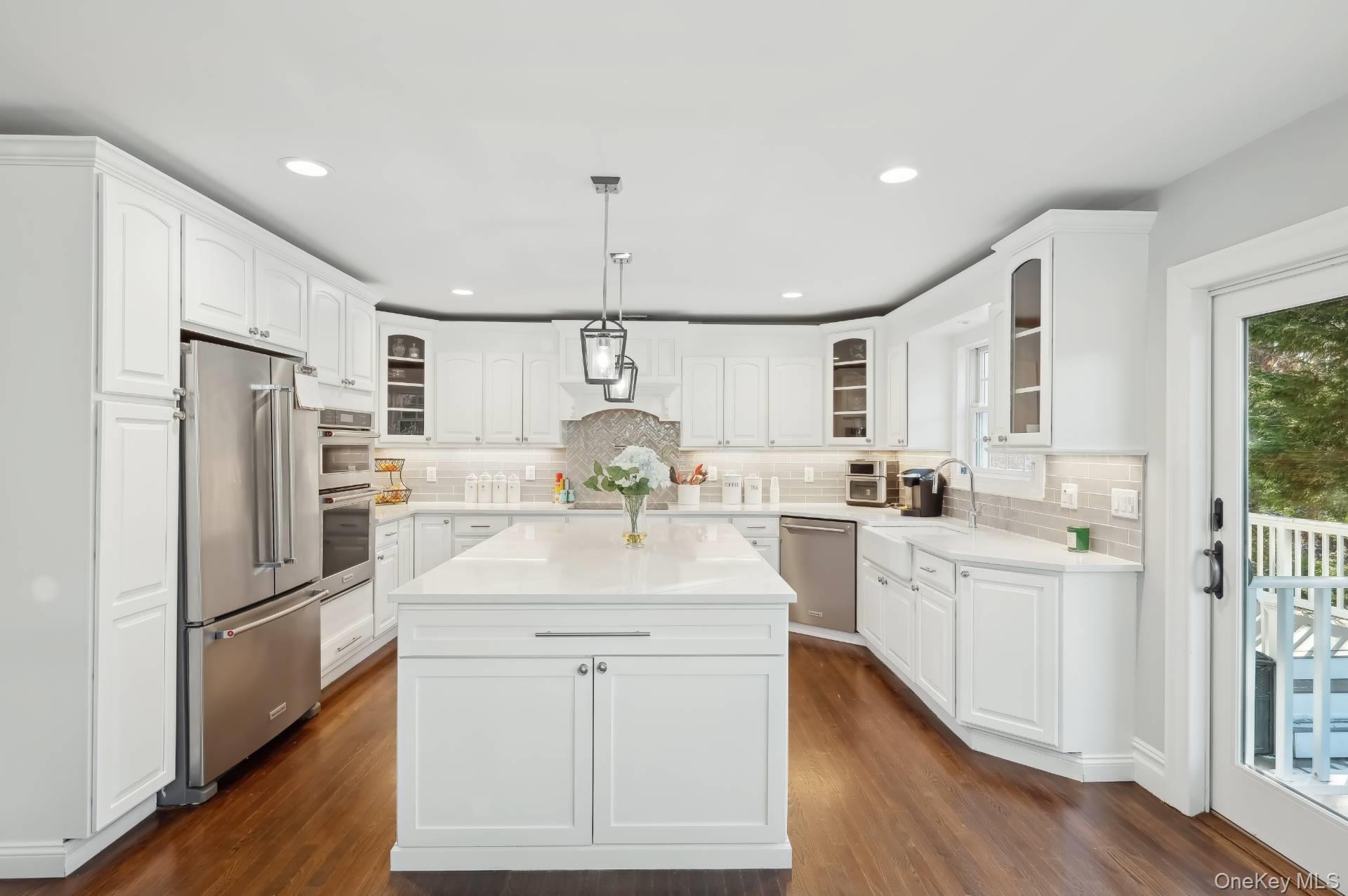 47 Bathing Beach Road Southampton, NY 11968 - Photo 8 of 20 a kitchen with white cabinets and stainless steel appliances