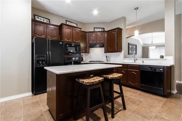 a kitchen with a sink refrigerator and cabinets