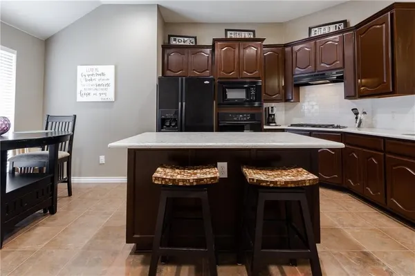 a kitchen with stainless steel appliances granite countertop a sink refrigerator and cabinets