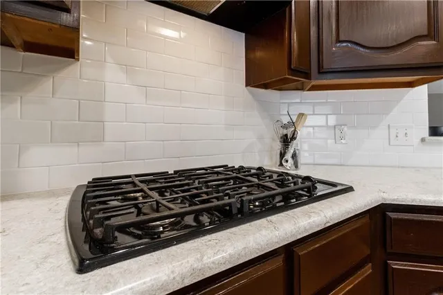 a kitchen with stainless steel appliances granite countertop a stove a sink and a microwave